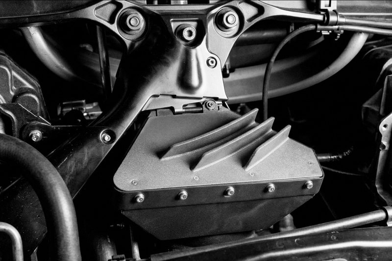 Additively manufactured vehicle panel with two curved stiffening ribs, installed in the car.